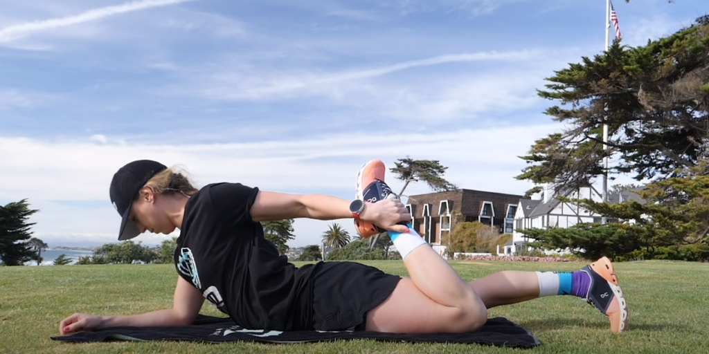 Person Lying on Grass, Legs Pulled Back for Stretching