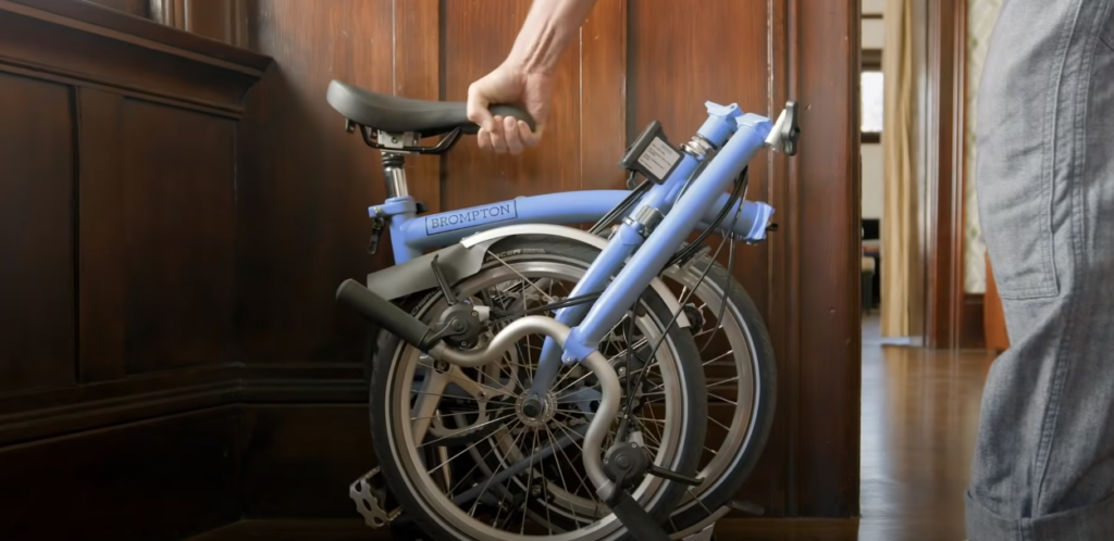 Hand gripping a foldable bicycle